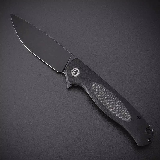 Petrified Fish Stamp PFB03 - 3.58" D2 Black Stonewashed Blade, Black G10 With Carbon Fibre Handle, Flipper